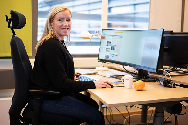 En person vid en dator och skrivbord på Bolagsverket tittar in mot kameran.