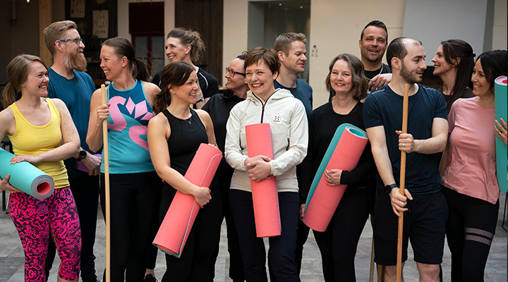 Gruppbild på personer i träningskläder och yogamattor