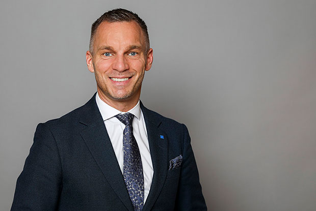 Erik Slottner. Med kavaj, slips och vit skjorta.