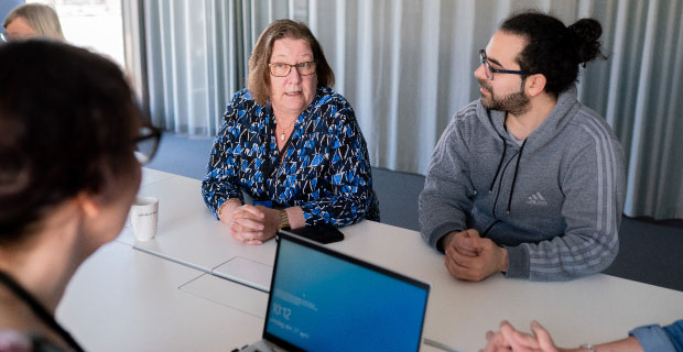 medarbetare sitter runt skrivbord och för dialog