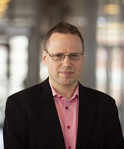Erik Janzon klädd i rosa skjorta och svart kavaj.