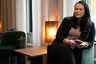 Fyra personer tittar tillsammans på en bärbar dator när de söker företagsinformation.