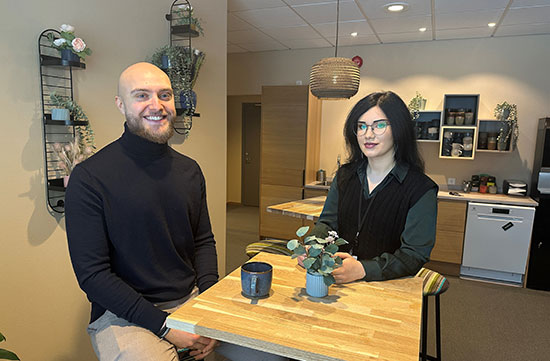 Julia och Marcus sitter vid ett bord med var sin kaffekopp framför sig.