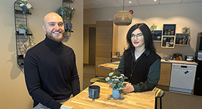 Julia och Marcus sitter vid ett bord med var sin kaffekopp framför sig.