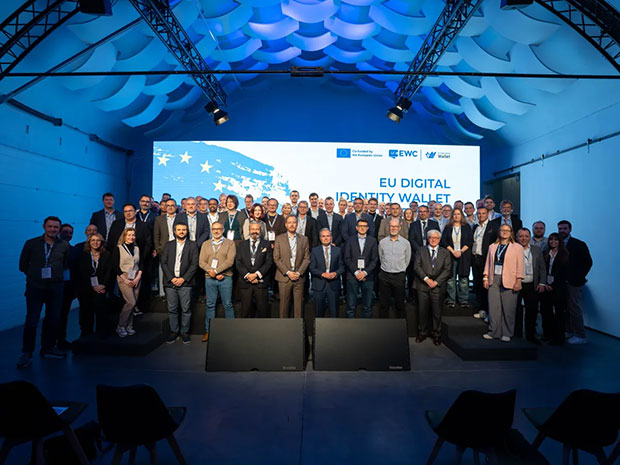Gruppbild på deltagare vid EWC:s generalförsamling i Madrid 2024, med texten "EU Digital Identity Wallet" i bakgrunden.