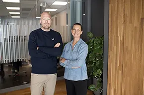 Peter Sellgren och Anna Mellberg Birberg står i en korridor på Bolagsverket och tittar in i kameran.