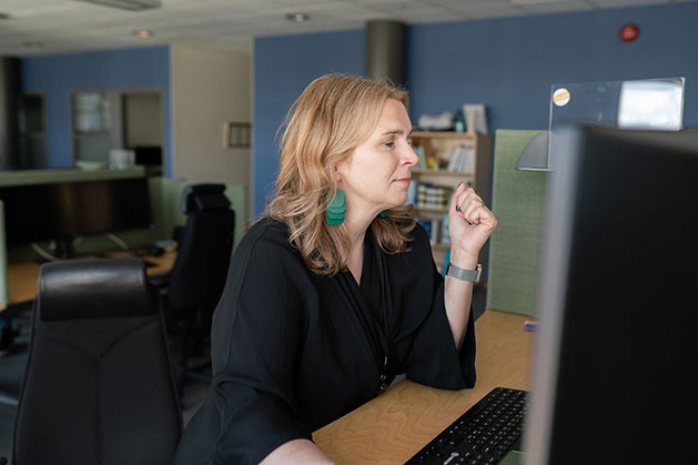 Kvinna sitter framför skärm